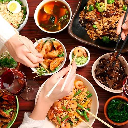 Grupo de amigos compartiendo mesa en un restaurante de comida asiática en Madrid organizado por Populit